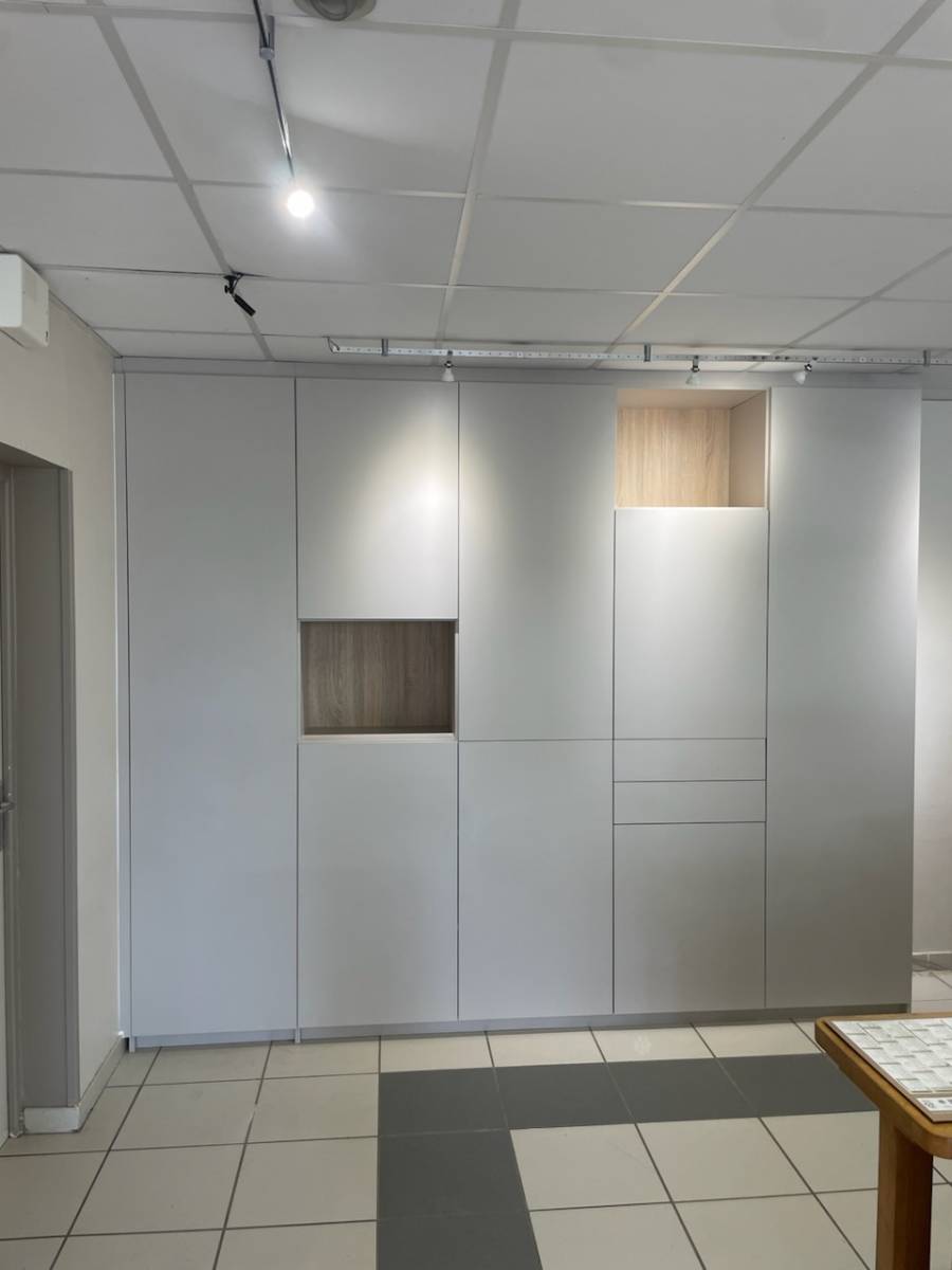 Conception d'un Placard de Rangements sur-mesure derrière la banque d'accueil d'un Office de Tourisme à Nissan-Les-Ensérunes, près de Béziers, dans l'Hérault